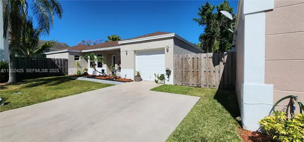 a front view of a house with a yard and potted plants