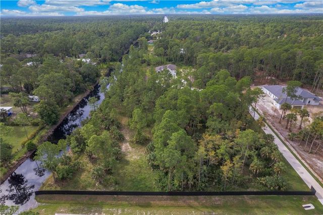 an aerial view of residential houses with outdoor space and trees