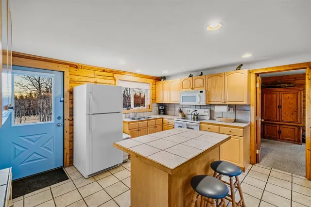 a kitchen with stainless steel appliances a stove a refrigerator and wooden cabinets