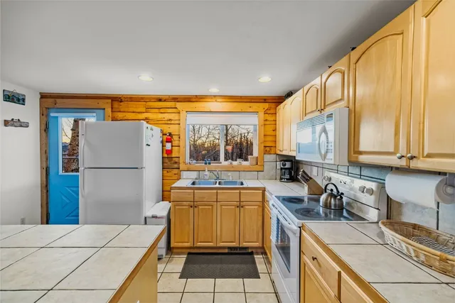a kitchen with a sink a refrigerator and cabinets