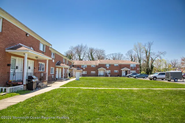 a view of a house with a big yard and large trees