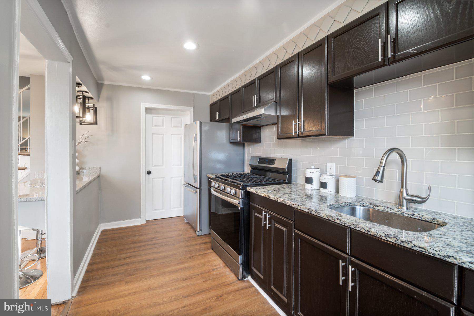 4801 Sinclair Lane Baltimore, MD 21206 - Photo 11 of 28 a kitchen with stainless steel appliances granite countertop a sink stove and refrigerator