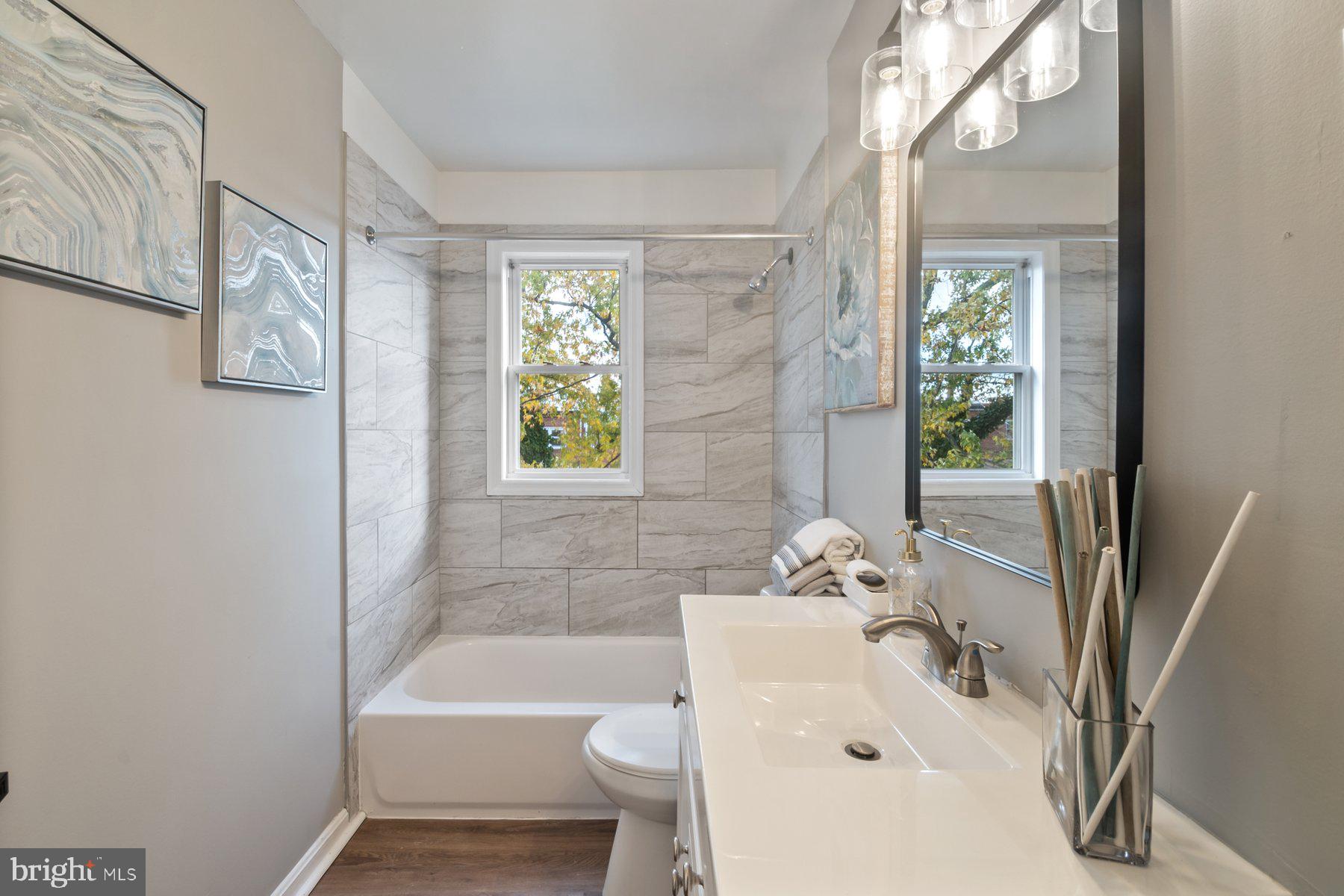 4801 Sinclair Lane Baltimore, MD 21206 - Photo 19 of 28 a bathroom with a sink a bathtub and a shower