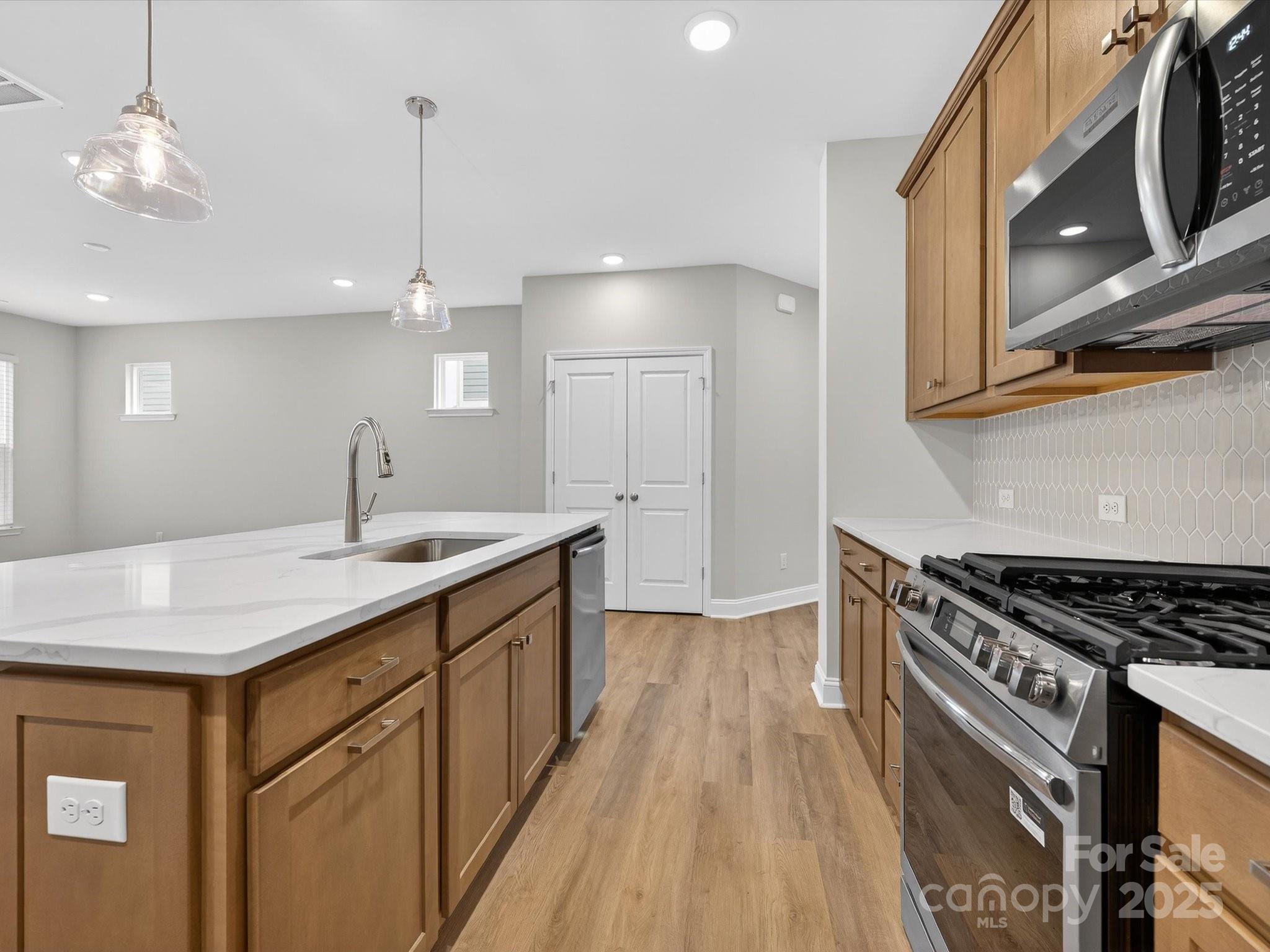 11445 Prosperity Church Road Huntersville, NC 28078 - Photo 9 of 35 a kitchen with a sink a stove cabinets and wooden floor