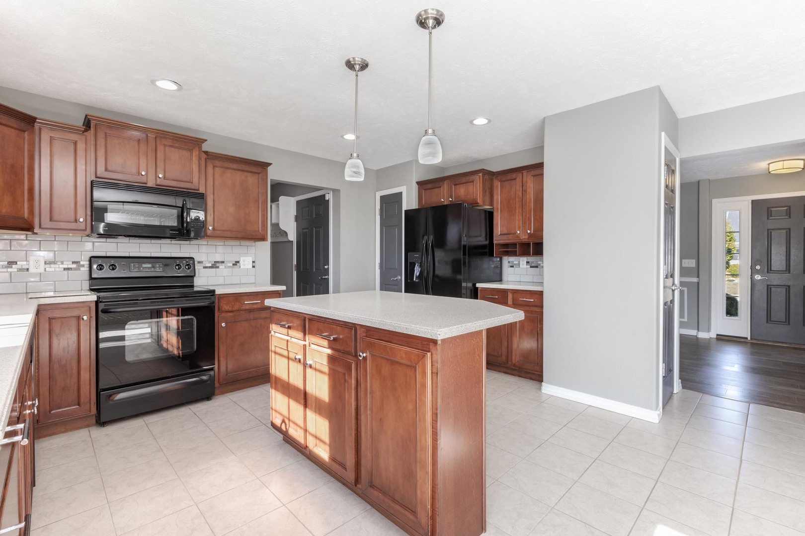 3291 Marimarsh Lane Normal, IL 61761 - Photo 29 of 55 a kitchen with stainless steel appliances kitchen island granite countertop a refrigerator a stove and a sink with wooden floor