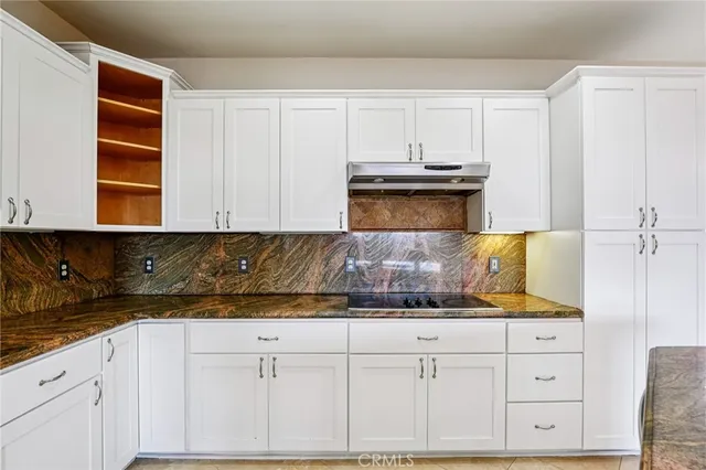 a kitchen with granite countertop a refrigerator and a stove