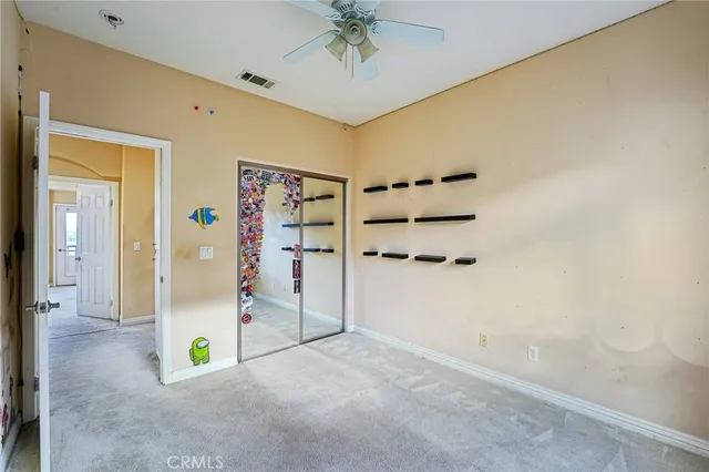 an empty room with a window and a fan