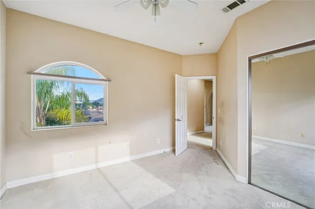 a view of an empty room with a ceiling fan