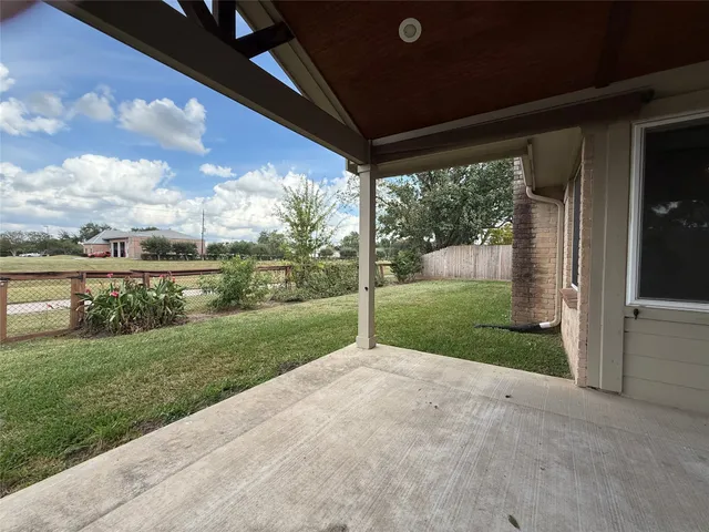 an empty room with wooden floor fireplace and windows