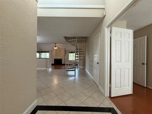 an empty room with windows and fireplace