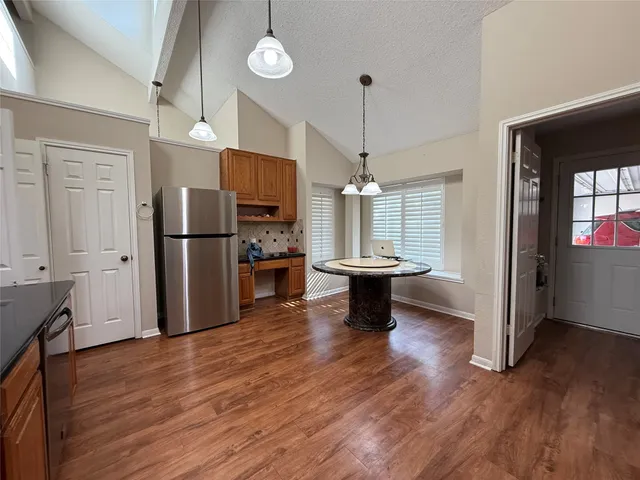 a view of a kitchen and dining room with wooden floor a fireplace