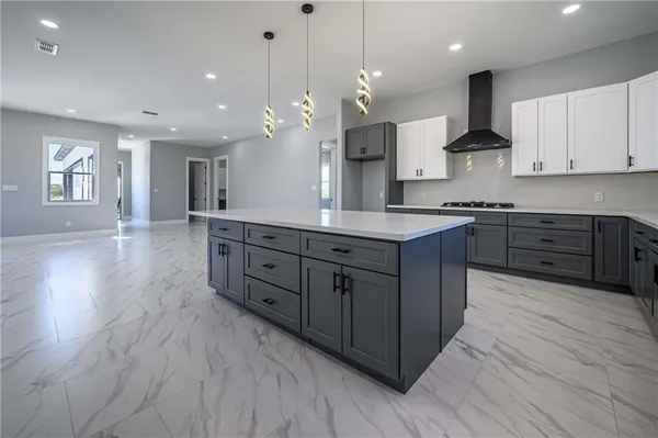 a kitchen with stainless steel appliances granite countertop a sink a stove and a refrigerator