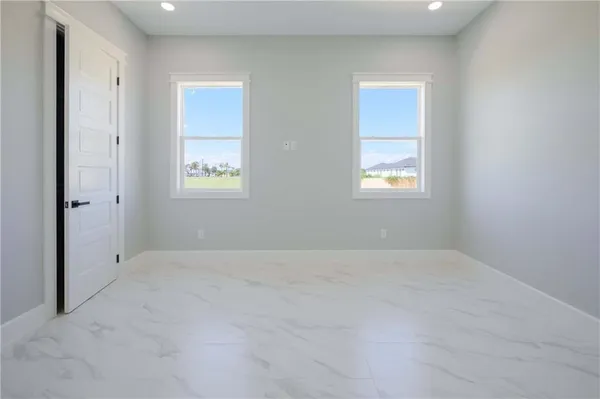an empty room with windows and fan