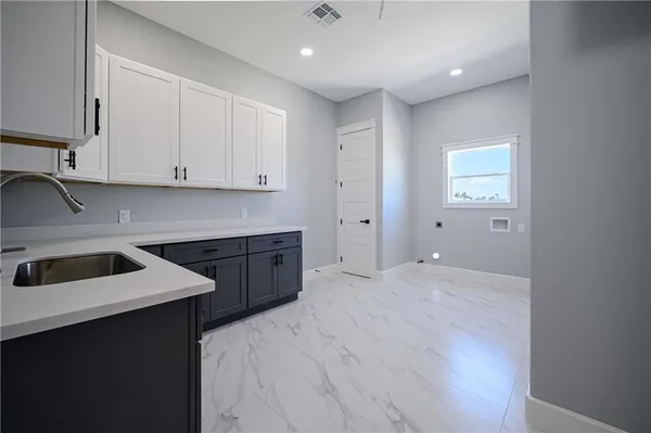 a view of a kitchen with white cabinets