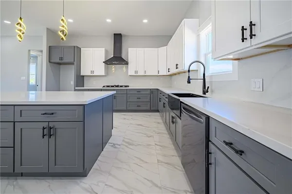 a large kitchen with stainless steel appliances granite countertop a large center island a sink a stove and a wooden floors