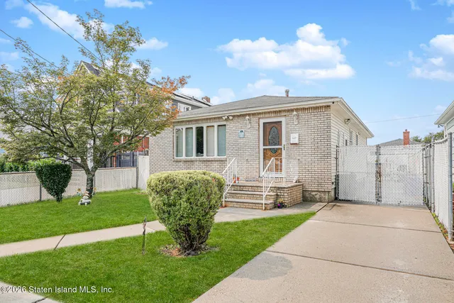 a view of a house with backyard and a tree