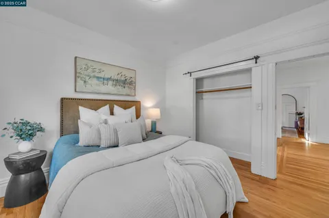 a bedroom with a bed and a painting on the wall