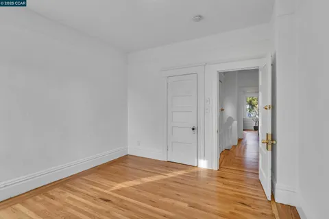 a bedroom with bed a potted plant and a window