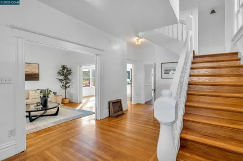 a view of a livingroom with wooden floor and stairs