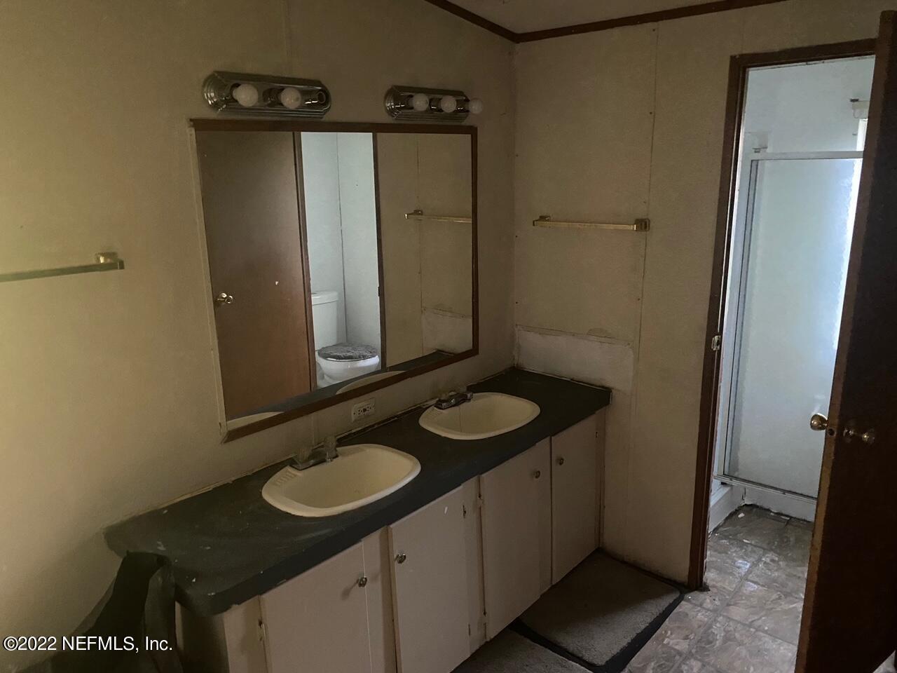 112 Pridgeon Street Interlachen, FL 32148 - Photo 14 of 21 a bathroom with a granite countertop sink and a mirror