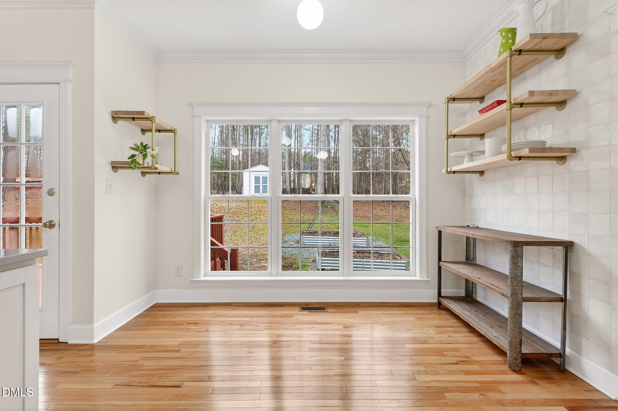 1328 Red Brick Road Garner, NC 27529 - Photo 22 of 64 a view of an empty room with a window and wooden floor
