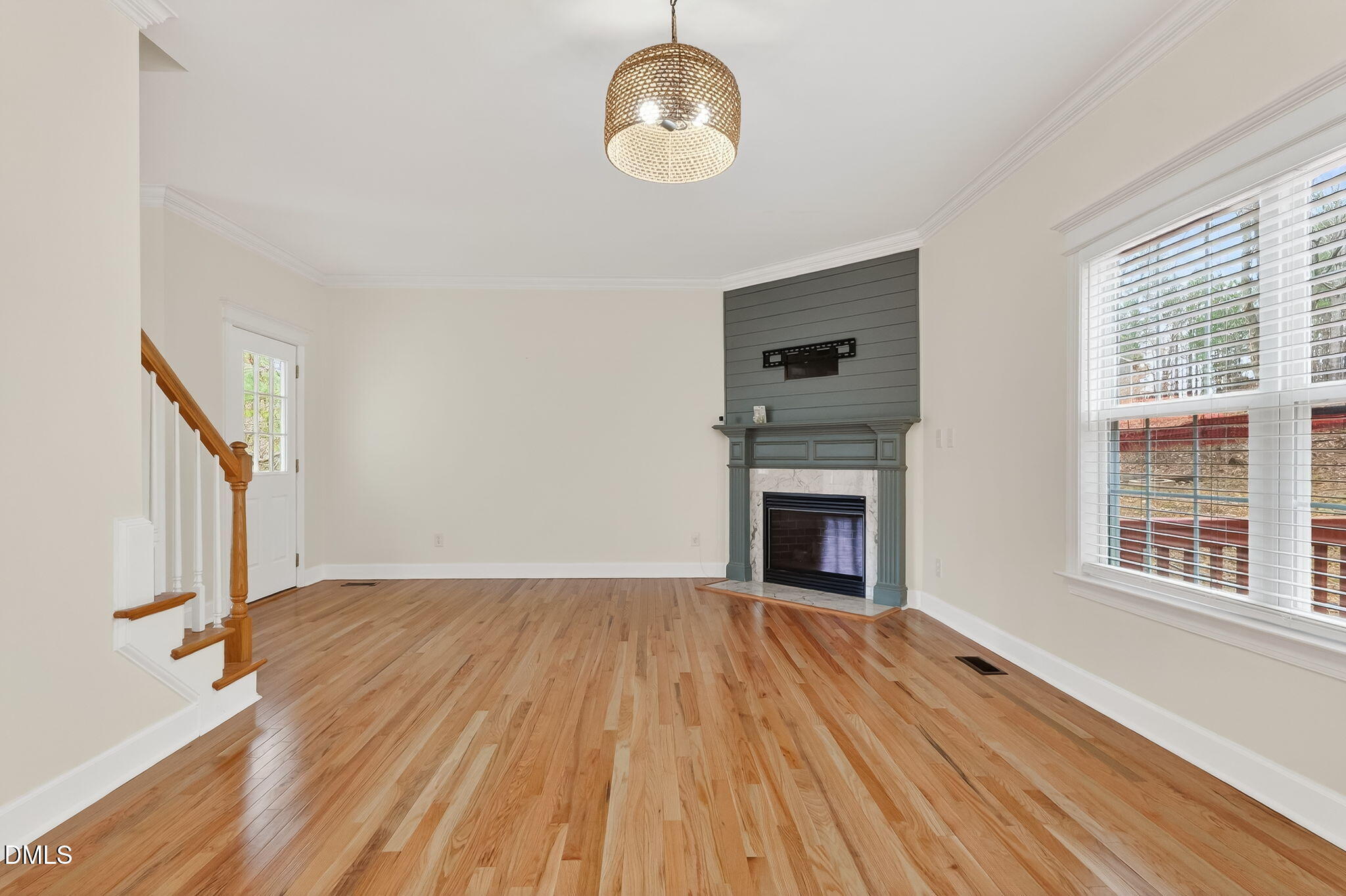 1328 Red Brick Road Garner, NC 27529 - Photo 10 of 64 a view of an empty room with wooden floor fireplace and a window