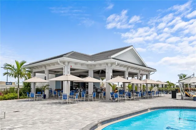 a view of a swimming pool with lawn chairs and plants