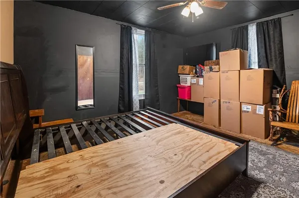 a bedroom with a bed and a flat tv screen on dresser