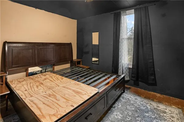 a bed sitting in a bedroom next to a window