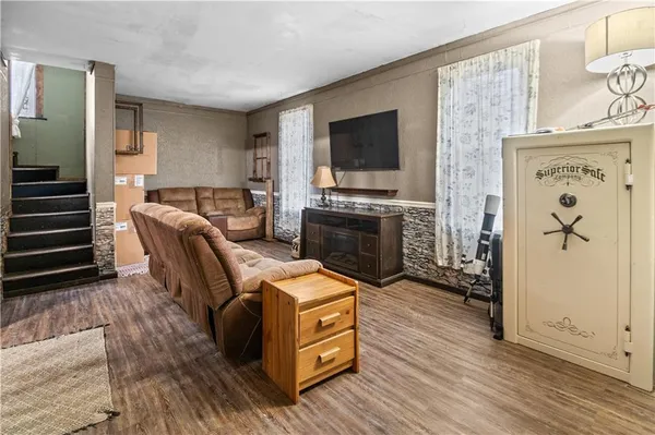 a view of a livingroom with furniture a flat screen tv and wooden floor