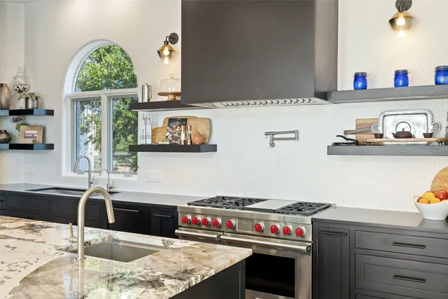 a kitchen with granite countertop a sink and a stove