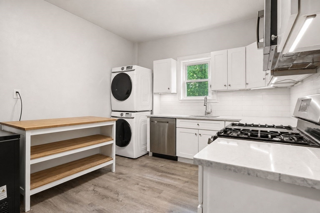 39 Union Street Boston, MA 02135 - Photo 6 of 33 a kitchen with white cabinets and a stove