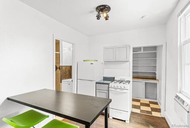 an empty room with wooden floor chandelier fan and closet area