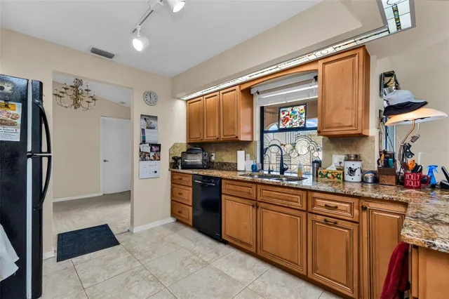 a kitchen with stainless steel appliances granite countertop a refrigerator and a sink