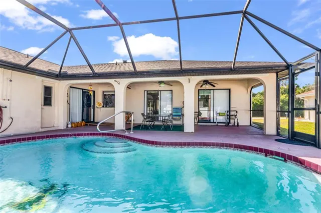 a view of a backyard with table and chairs under an umbrella