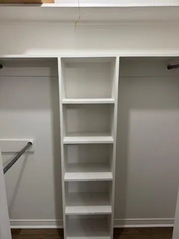 a view of walk in closet with empty racks