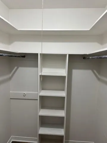 a view of walk in closet with empty racks