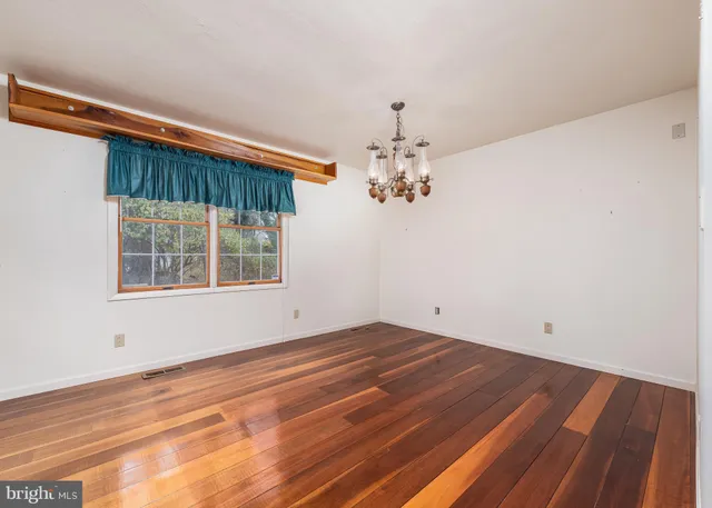 a view of a room with wooden floor and chandelier