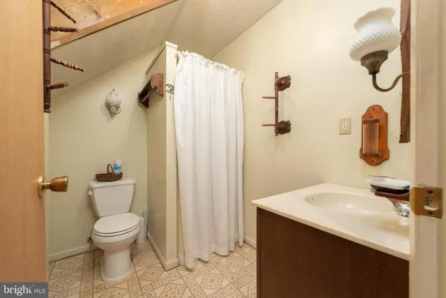 a bathroom with a granite countertop sink a toilet and a shower