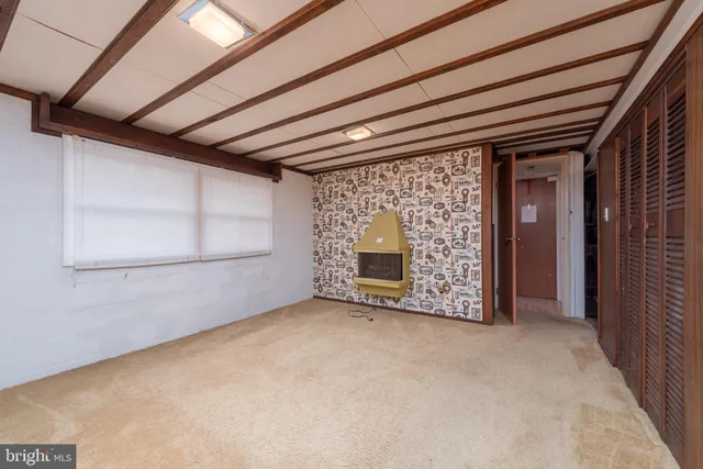 a view of an empty room with a fireplace and a window