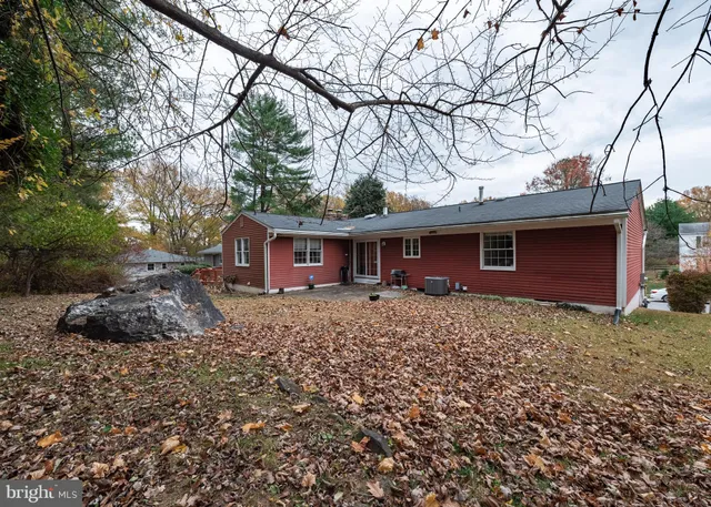a view of a house with a yard tree and wooden fence