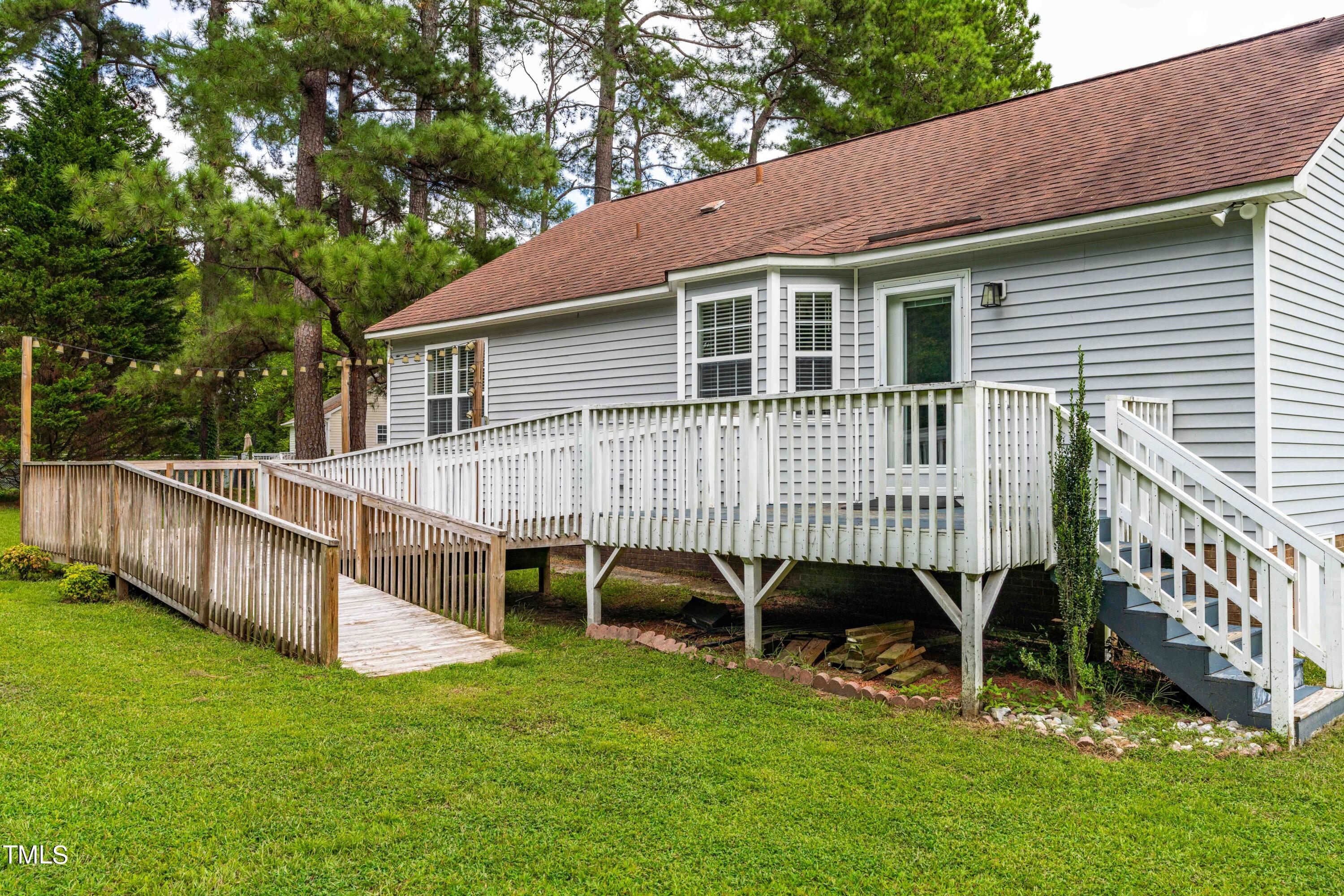 320 Amber Lane Willow Spring, NC 27592 - Photo 13 of 16 a view of a house with a backyard and a deck