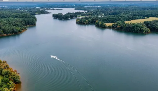 an aerial view of a house with a yard and lake view