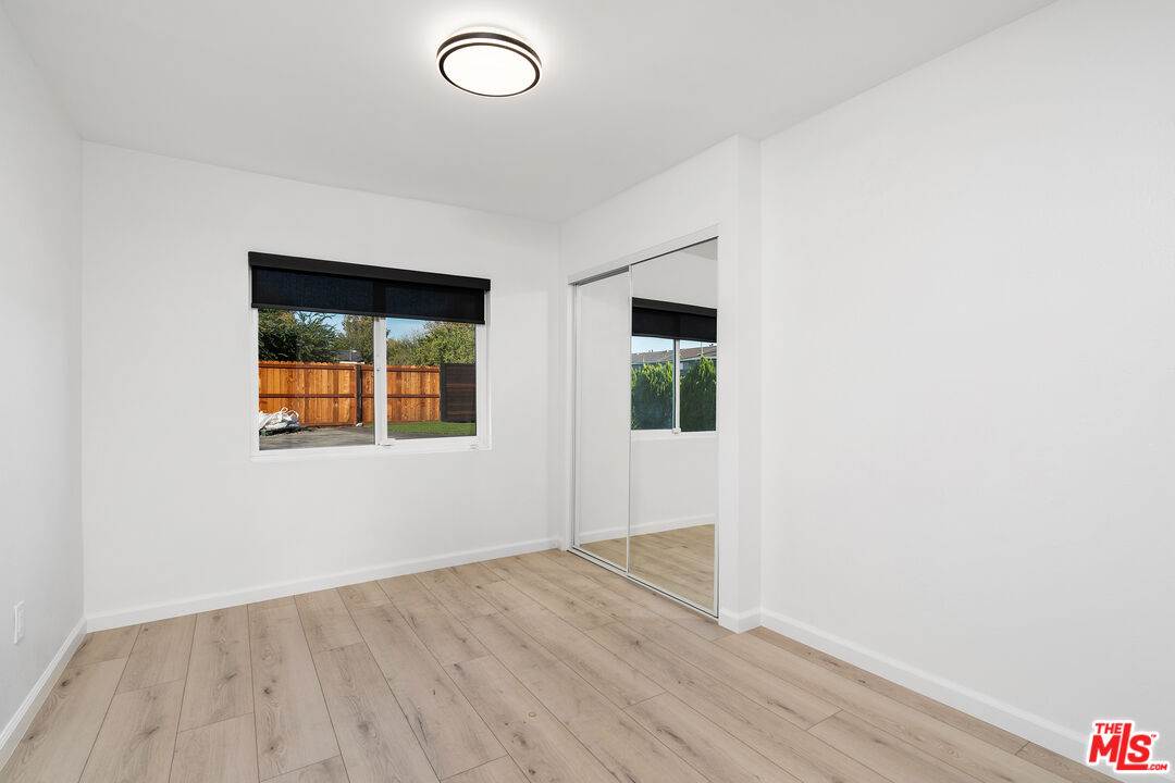 20850 Chase Street Winnetka, CA 91306 - Photo 16 of 25 an empty room with wooden floor and windows