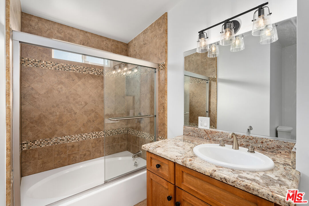 20850 Chase Street Winnetka, CA 91306 - Photo 17 of 25 a bathroom with a granite countertop shower sink and mirror