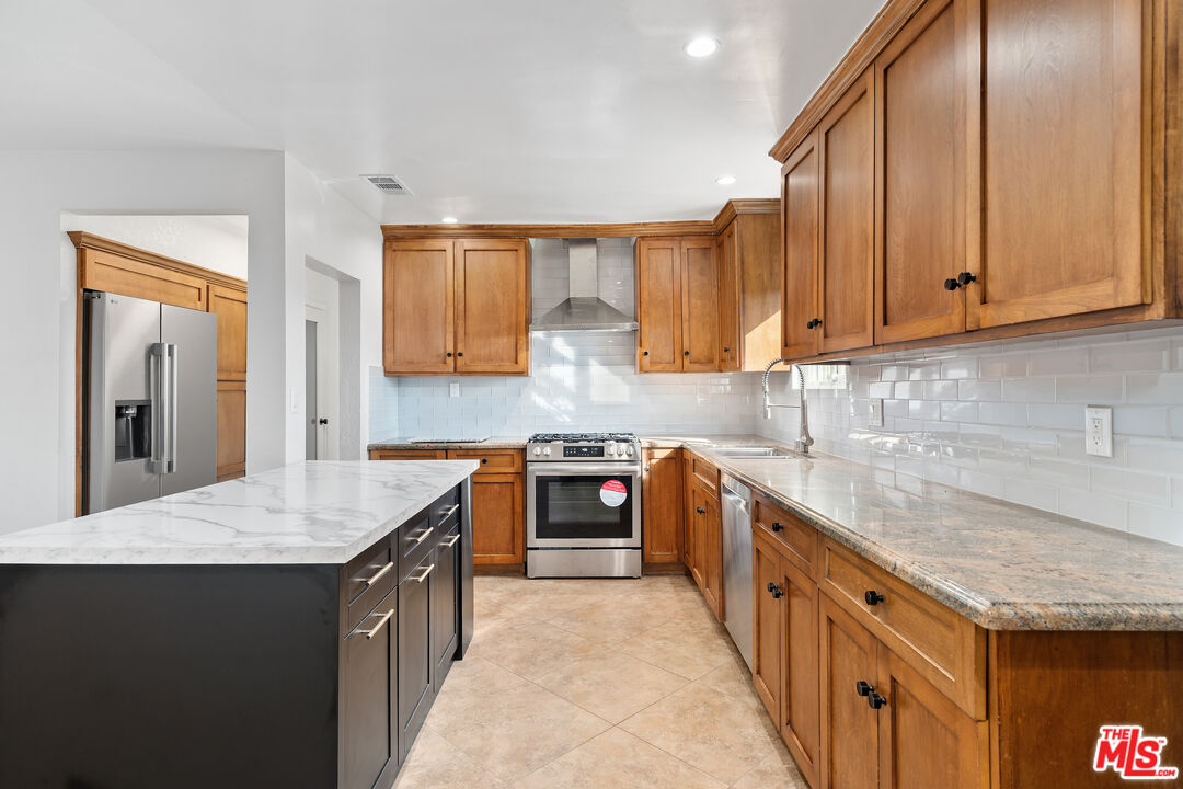 20850 Chase Street Winnetka, CA 91306 - Photo 9 of 25 a kitchen with stainless steel appliances granite countertop a sink stove and cabinets