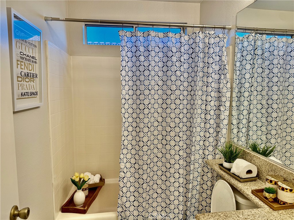 12966 Sundown Road Victorville, CA 92392 - Photo 12 of 20 a bathroom with a shower curtain