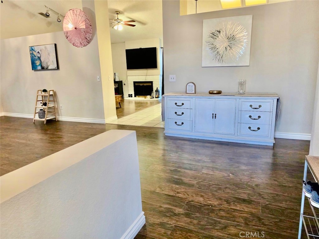 12966 Sundown Road Victorville, CA 92392 - Photo 2 of 20 a living room with hard wood floors and a flat screen tv