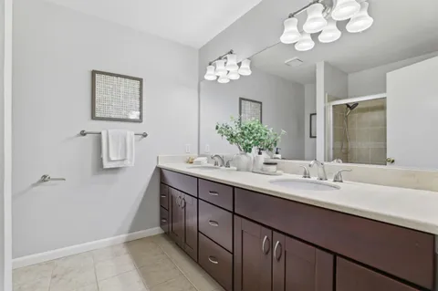 a bathroom with a sink a large mirror and a shower