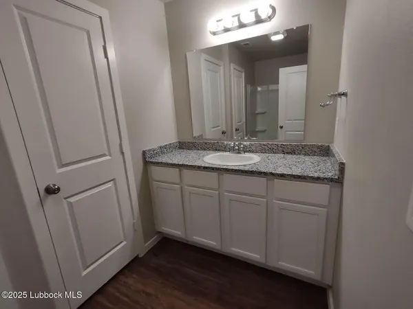 a bathroom with a granite countertop sink and a mirror